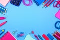 Pink and blue school supplies frame over a pastel blue background Royalty Free Stock Photo