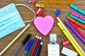 School supplies , a heart shape note pad ,a mouth mask and liquid hand sanitizer