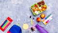 School supplies and lunchbox with food for kids. Colorful stationery layout on multicolor background, copy space Royalty Free Stock Photo
