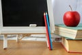 School supplies, miniature chalk board, a stack of books and an apple on the table, soft focus Royalty Free Stock Photo