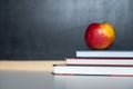 School supplies on old wooden table, near blackboard, close up Royalty Free Stock Photo