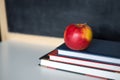 School supplies on old wooden table, near blackboard, close up Royalty Free Stock Photo