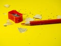 School supplies. Pencil sharpener . Red pencil. Wood shavings. The process of preparing for work. Creative mess Royalty Free Stock Photo