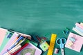 School supplies, pens, pencils, notebooks, ruler, scissors on a  against the background of a green school board Royalty Free Stock Photo