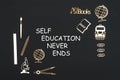 School supplies placed on black background with text self education never ends