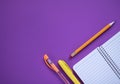 School supplies on purple background. Notebook open page. Royalty Free Stock Photo