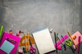 School supplies for school: notepad, pencils, pink ruler, compasses scattered on a gray table. Top view.