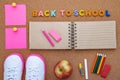 School supplies, slips, letters and an open notebook on a cork background. The inscription BACK TO SCHOOL Royalty Free Stock Photo