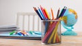 School supplies on the table. Pencils in stand, globe and notebooks