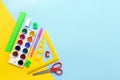 school supplies - triangle, ruler, watercolor, scissors on a yellow-blue background, copy space, back to school