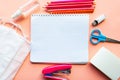 School supplies, white mockup notebook and medical mask on pink backgrpund. Back to school concept.