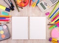 School supplies on wooden desk wirh open notebook Royalty Free Stock Photo