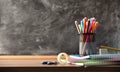 School supplies on wooden table and blackboard in the background Royalty Free Stock Photo