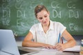 School teacher checking book in classroom