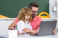 School teacher and child pupil learning at laptop computer, studying with online education e-learning in class. Teacher Royalty Free Stock Photo
