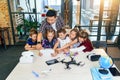 School teacher at desk works with five young pupils using digital tablet computer in technology class. Development Royalty Free Stock Photo