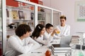 School teacher gives chemistry lesson to children in a laboratory with flasks with liquids for experiments. Education