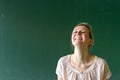 School teacher laughing in front of chalkboard Royalty Free Stock Photo