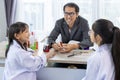 School teacher and students in scientific lab gown are learning about elements while studying science lesson in the classroom for Royalty Free Stock Photo