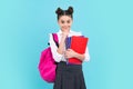 School teenager child girl with book and copybook. Teenager student, blue background. Learning and knowledge