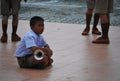 Photo of single boy sitting with trumpet on the street at school in Thailand, Asia