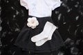 School uniform with white shirt, socks and dark denim skirt on a black background. Flatlay, top view, copy space Royalty Free Stock Photo