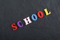 SCHOOL word on black board background composed from colorful abc alphabet block wooden letters, copy space for ad text. Learning Royalty Free Stock Photo