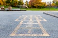 School and schoolyard with hopscotch and playground for elementary students in evening in fall season Royalty Free Stock Photo