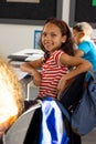 In school, young biracial girl and two friends are sitting in the classroom