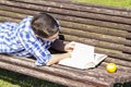 School.Young boy reading a book in the Park Bench, summer Royalty Free Stock Photo