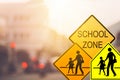 School zone warning sign on blur traffic road with colorful bokeh light abstract background Royalty Free Stock Photo