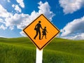 School zone warning yellow traffic road sign  on blue sky background closeup. Royalty Free Stock Photo