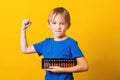 Schoolboy with abacus over yellow background. Kid study at mental arithmetic school
