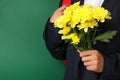 Schoolboy backpack and chrysanthemums on green background Royalty Free Stock Photo