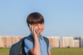 Schoolboy with backpack in his hands mobile phone against the background of the city landscape Royalty Free Stock Photo