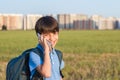 Schoolboy with backpack in his hands mobile phone against the background of the city landscape Royalty Free Stock Photo
