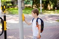 Schoolboy with backpack pressing a button on traffic Royalty Free Stock Photo