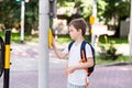 Schoolboy with backpack pressing a button on traffic Royalty Free Stock Photo