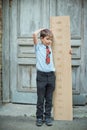 Schoolboy with big ruler standing on wooden background. Farewell Bell. day of knowledge. beginning of the school year. education a Royalty Free Stock Photo