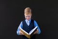 Schoolboy with a book on a black background Royalty Free Stock Photo