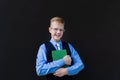 Schoolboy with a book on a black background Royalty Free Stock Photo