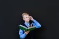 Schoolboy with a book on a black background Royalty Free Stock Photo