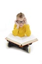 Schoolboy bored, frustrated and overwhelmed by studying homework. Little boy wearing eyeglasses sitting down on floor Royalty Free Stock Photo
