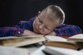 Schoolboy boy with glasses sleeps on books. Black background. Distance learning during the coronavirus pandemic Royalty Free Stock Photo