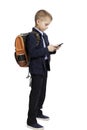 Schoolboy boy in uniform with a backpack with a phone in his hand stands. Full height. Back to school. Online and distance Royalty Free Stock Photo