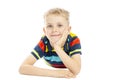 A schoolboy in a bright striped sweater is lying on the floor and smiling. Isolated over white background