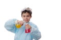 Schoolboy at chemistry class, pours solution from laboratory flask into beaker, observing the going on chemical reaction Royalty Free Stock Photo