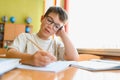 Schoolboy doing homework, learning and studying in classroom Royalty Free Stock Photo