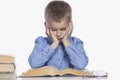 A schoolboy is doing homework at the table. Sadness and tiredness from studying. Isolated over white background Royalty Free Stock Photo