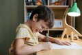 A schoolboy doing math lesson sitting at desk in the children room Royalty Free Stock Photo